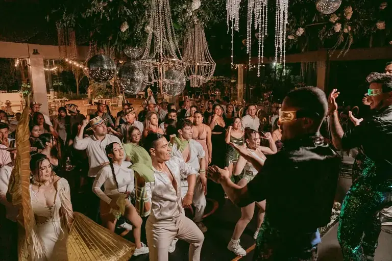 Pista llena de invitados bailando bajo bolas disco