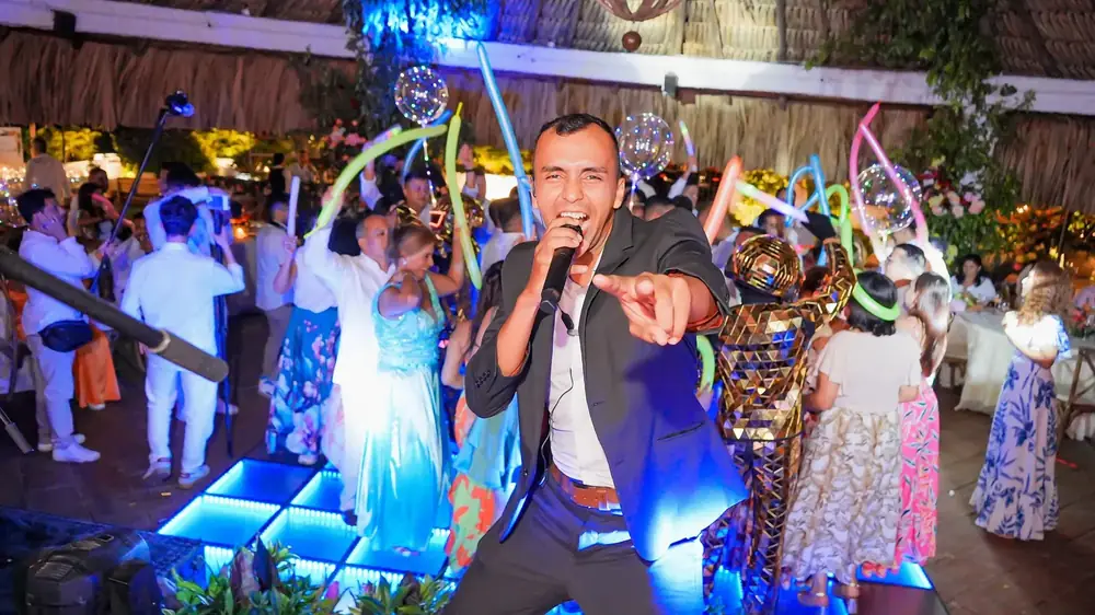 El animador en la tarima LED con los invitados bailando detrás